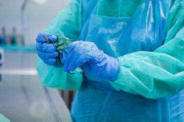 A healthcare professional's gloved hands in protective uniform meticulously clean a medical...