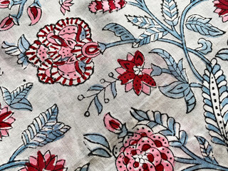 A detailed close-up captures the elegance of Mughal floral block printing on cotton fabric.