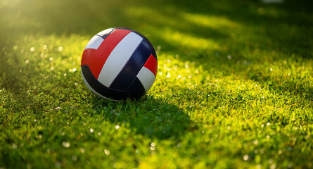 The volleyball ball is lying on the green grass.Summer ball games in the park.