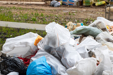 A large pile of trash is sitting on the ground in a nearby field