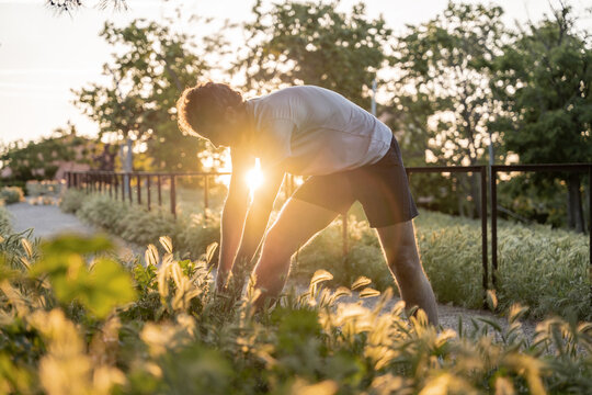 Athlete doing stretching exercises in nature