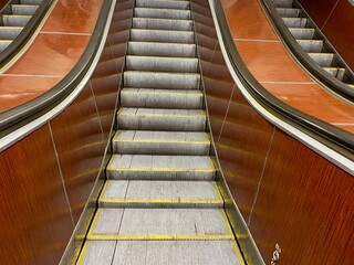 Symmetrical view of an old retro-style escalator with wooden panels. Close-up view of a classic...