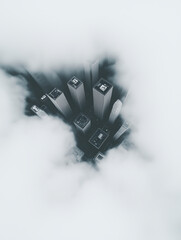 Aerial view of skyscrapers emerging through dense clouds from above. Mystery, ambition and modern isolation