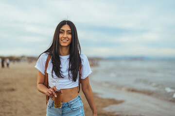 Young Woman Enjoying a Refreshing Drink by the Beachside