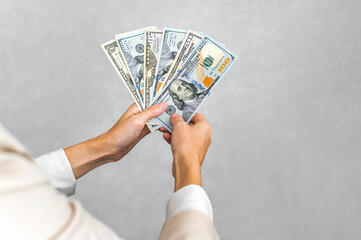 Hands Holding US Dollar Bills: Finance and Wealth Concept