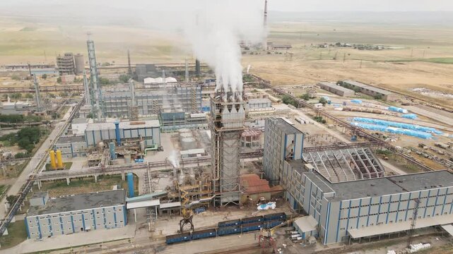 Aerial view of Rustavi Azot chemical factory with smokestacks, overgrown wasteland, and polluted surroundings showing industrial production and environmental damage in Georgia