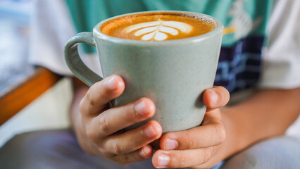 Holding a cup of coffee with latte art