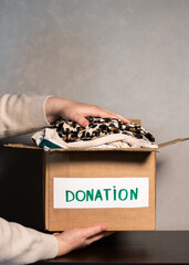 Woman gives her old clothes to charity, helping people in need who are caught up in military action.