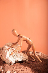 Maniqui en haciendo trabajos en tierra y con roca. Tonos naranjas