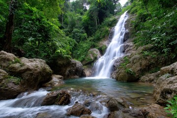 Fototapeta premium Majestic waterfall cascades through lush greenery in a tranquil forest setting