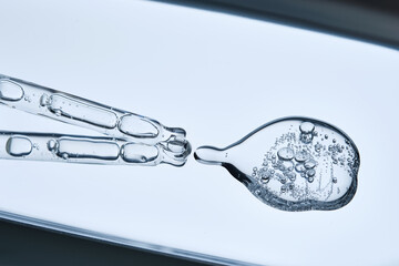 The texture of the serum with bubbles spilling onto the blue surface.