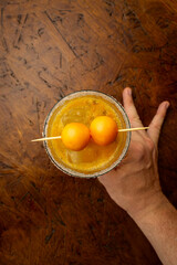 Tropical Passion Fruit Margarita cocktail with a sugar rim and goldenberry garnish, a refreshing...