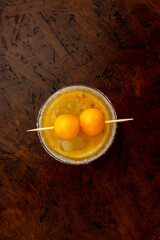 Tropical Passion Fruit Margarita cocktail with a sugar rim and goldenberry garnish, a refreshing...