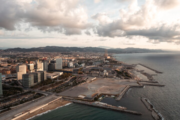 An aerial view of Barcelona's expansive coastline, featuring a wide sandy beach, the urban sprawl,...