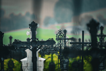 Artistic photo of rapprochement of cast iron crosses at the cemetery in the rain, with a fucked up...