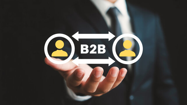 A hand in a black suit holds a glowing B2B digital interface with yellow profile icons, arrows, and reflections on dark background