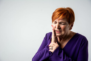 Senior woman suffering from severe toothache with painful grimace, dental health problem, isolated...