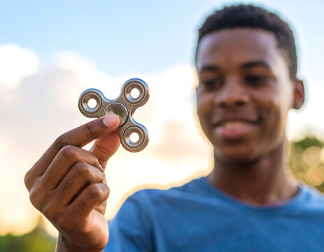Fidget spinner held by young boy outdoors, showcasing joy and focus. scene captures moment of playfulness and ADHD awareness