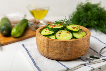 Cucumber salad on a wooden background.Homemade salad with fresh vegetables, cucumber, tomato, sweet...