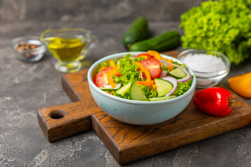 Cucumber salad on a wooden background.Homemade salad with fresh vegetables, cucumber, tomato, sweet...