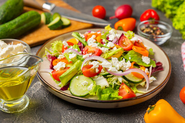 Cucumber salad on a wooden background.Homemade salad with fresh vegetables, cucumber, tomato, sweet...