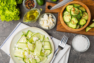 Cucumber salad on a wooden background.Homemade salad with fresh vegetables, cucumber, tomato, sweet...