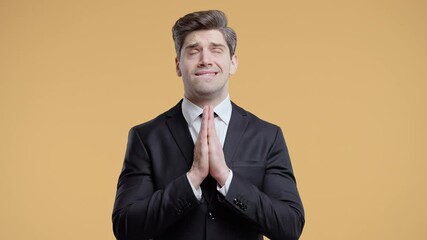 Businessman praying with palms together in sincere silent request. Hope, faith
