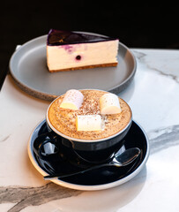 Cinnamon Latte with Marshmallows and Slice of Blueberry Cheesecake on Marble Table