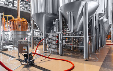 Pipes stainless steel brewing equipment, Brewery food industrial production concept. Large tanks in...