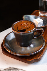 Authentic Turkish Coffee Served in Ceramic Cup with Glass of Water and Traditional Lokum on Wooden Tray