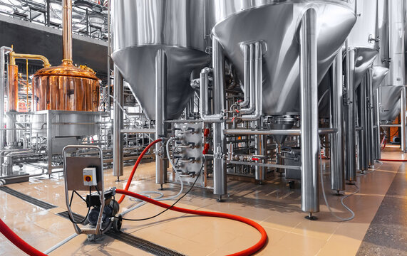 Pipes stainless steel brewing equipment, Brewery food industrial production concept. Large tanks in modern beer factory