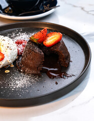 Sliced Molten Chocolate Lava Cake with Strawberries and Vanilla Ice Cream beside Hot Americano