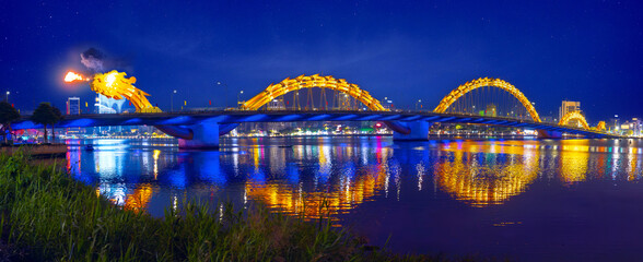 Dragon bridge with burn show and illuminated at night over han river in Da nang, famous landmark Vietnam