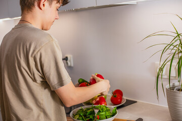  Boy choosing fresh vegetables to prepare vegetarian salad, healthy eating of teenager