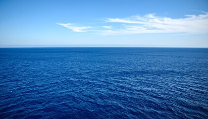 Obraz premium A serene view of the ocean with blue sky and a few scattered white clouds
