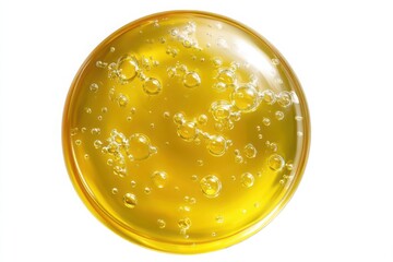 A circular drop of yellow oil, cosmetic serum, honey, or liquid gel isolated on a clean white background.