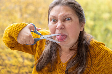 woman cutting off tongue, not to say too much, Antique scissors playfully posed near woman's tongue, symbolizing idea of holding back words, idea of keeping quiet