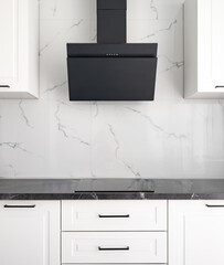 Black range hood on a white modern kitchen with marble backsplash, black induction cooktop and...