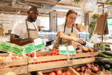 Green eco store workers stocking fresh produce
