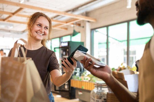 Woman making contactless payment at eco-friendly store