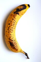 Ripe banana with black spots on white background.
Contrast between bright yellow fruit and white background

