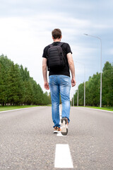Man taking step forward on empty road, symbolizing solitude, inner strength and determination to...