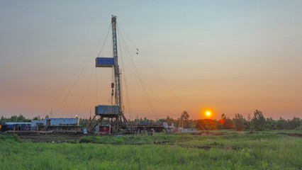 Fototapeta premium Drilling a well in an oil field. Mobile drilling rig and drilling equipment. Summer. Beautiful sky and nature.