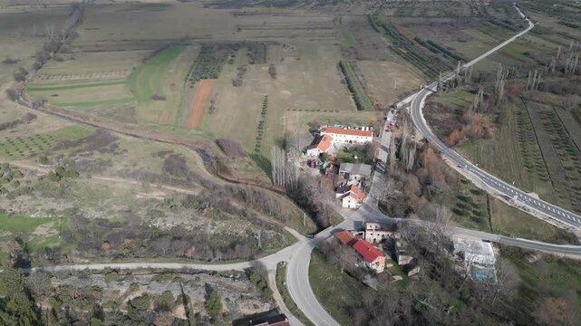 Vista a&eacute;rea de Bribirske Mostine, Croacia. El dron muestra una casa rural y se abre hacia un paisaje de monta&ntilde;as y tierras verdes.