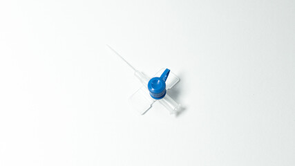 Sterile intravenous cannula without needle, viewed from above. Blue injection port and transparent...