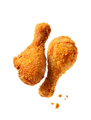 Two golden brown crispy fried chicken drumsticks on food