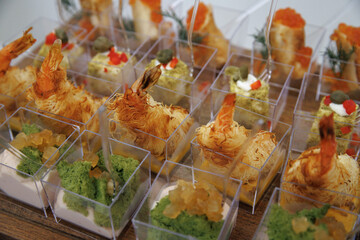  Tiramisu cups topped with fresh raspberries and colorful crumbs served on a wooden platter. Small...