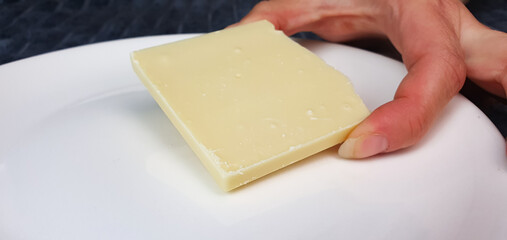 White chocolate,bar, pieces of natural white chocolate on a plate, a woman breaks off white chocolate.
