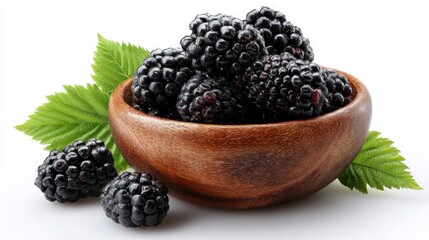 Tasty blackberries in a wooden bowl accompanied by leaves, on a white background