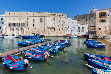 Harbour in Monopolis old town with ancient buildings and blue fishing boats.
